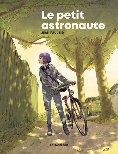 La couverture de Le petit astronaute de Jean-Paul Eid, un jeune femme avec son vélo regarde par dessus une clôture sur un trottoir bordé d'arbres et de voitures stationnées. 